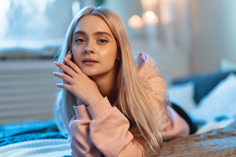 Woman with platinum blonde hair using proper hair care products