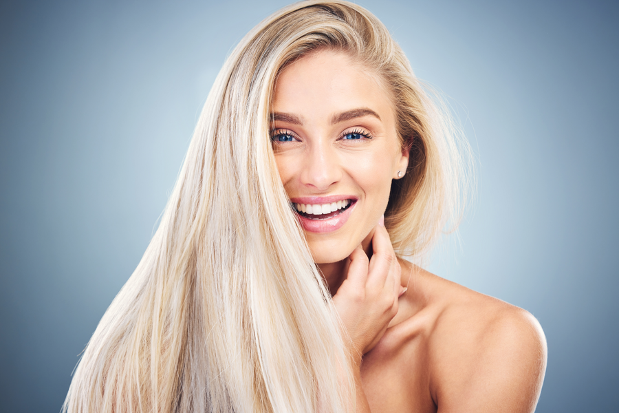 Woman with healthy blonde hair using color-safe products